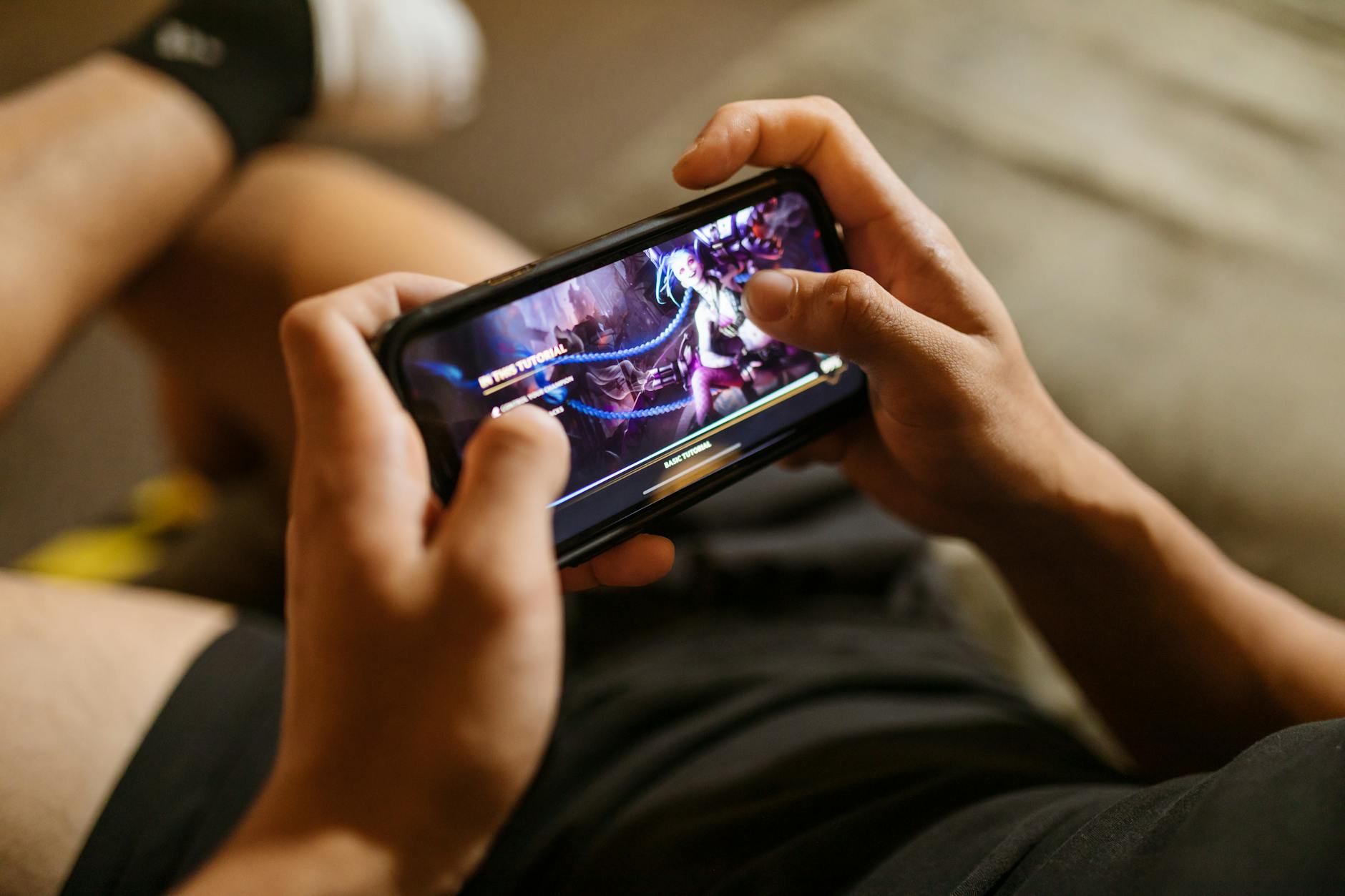 Người dùng thư giãn với smartphone khi chơi game giải trí tại nhà